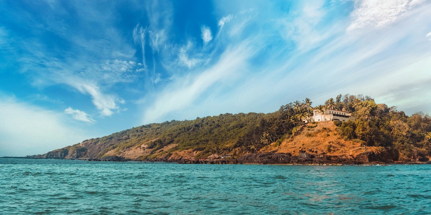 Image of Baga Beach, clear turquoise colour water and lush green island and resorts