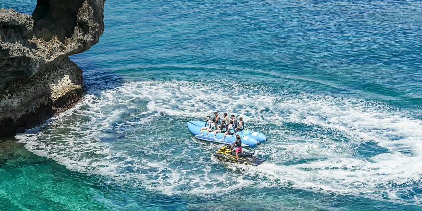 An image displaying a banana boat filled with riders, one of the top Mandwa Beach water sports.