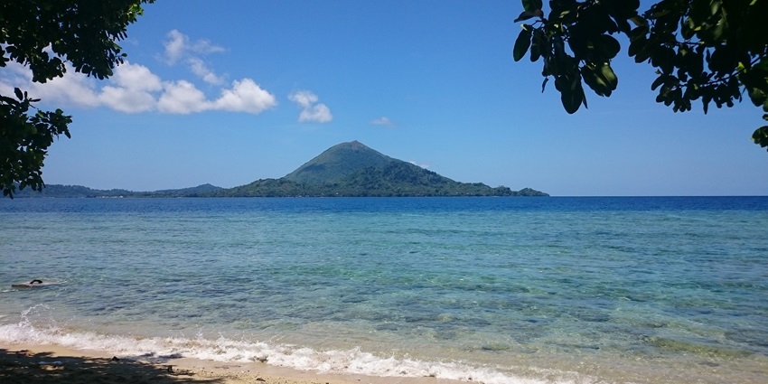 View from the coast of the lush vegetation and houses in the Run, Banda islands in Maluku