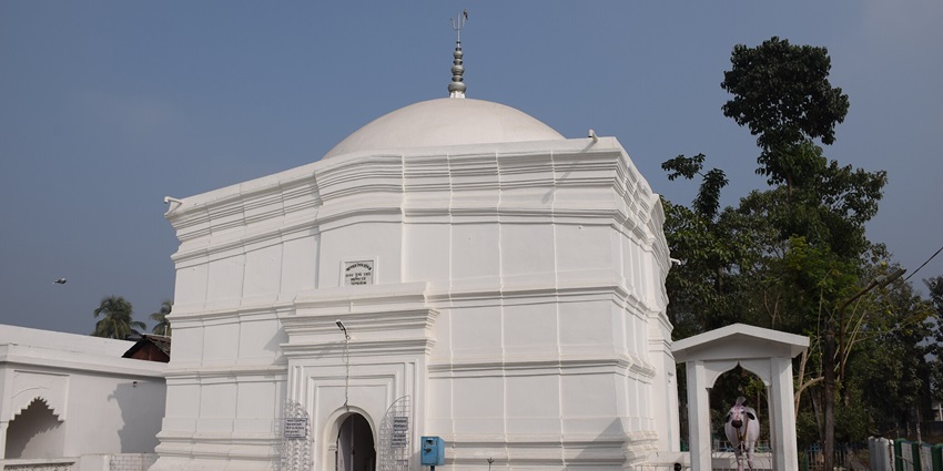 A beautiful temple on a mountain surrounded by lush greenery and a clear blue sky