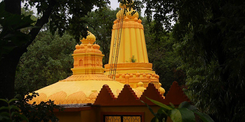 View of Baneshwar temple surrounded by lush trees and greenery