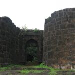 Panoramic view of Bankot Fort, highlighting its stone architecture and coastal surroundings.