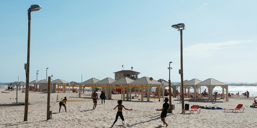 An action-packed game of beach volleyball being played on the sun-kissed sands of Bingin Beach.