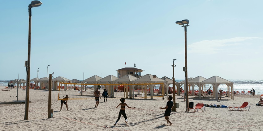 A game of beach volleyball being played on the sun-kissed sands of Blue Point Beach.