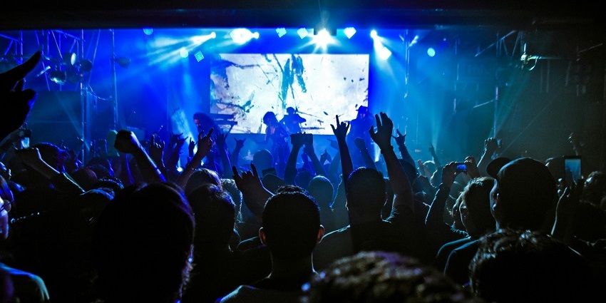 An image of a vibrant beach party with sand, surf, and music at one of the parties.