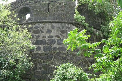 A distant view of the ruins of Belapur Fort, located in Navi Mumbai, surrounded by greenery.