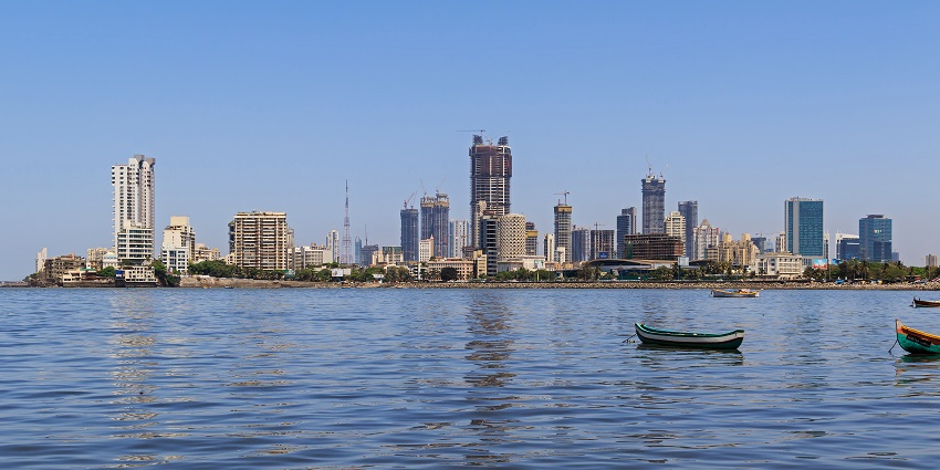 Lotus Colony skyline with modern buildings, boats and kayaks floating on the waters.