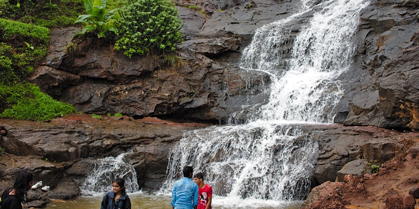 The waterfall around the spot for kayaking in Lonavala cascades through mountains covered in greenery.