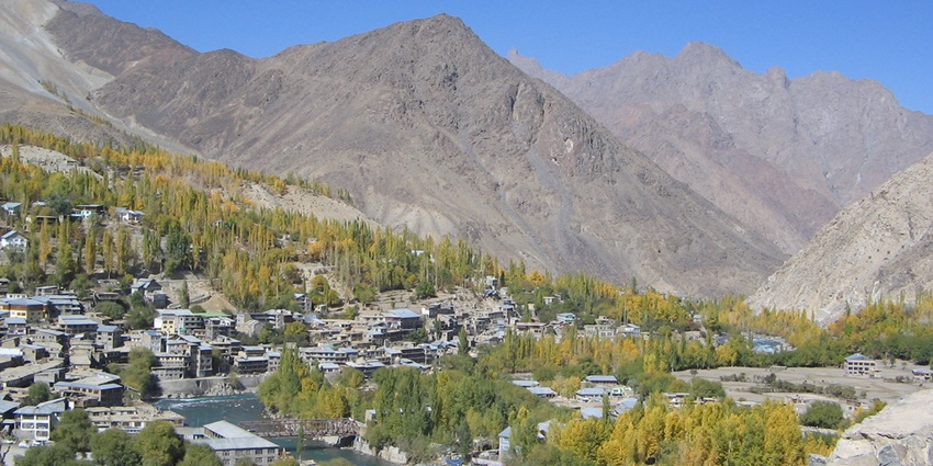 Panoramic view of Kargil Town, surrounded by mountains and clear blue skies.