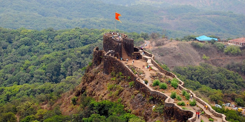 Top view of the fort with a flag hoisting at the top and the building surrounded by lush greenery