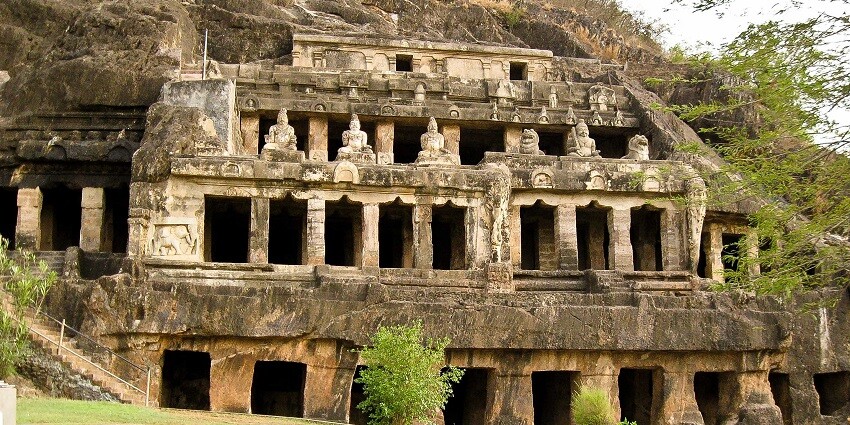 View of the halls of Rudreshwar caves with lush bushes around it