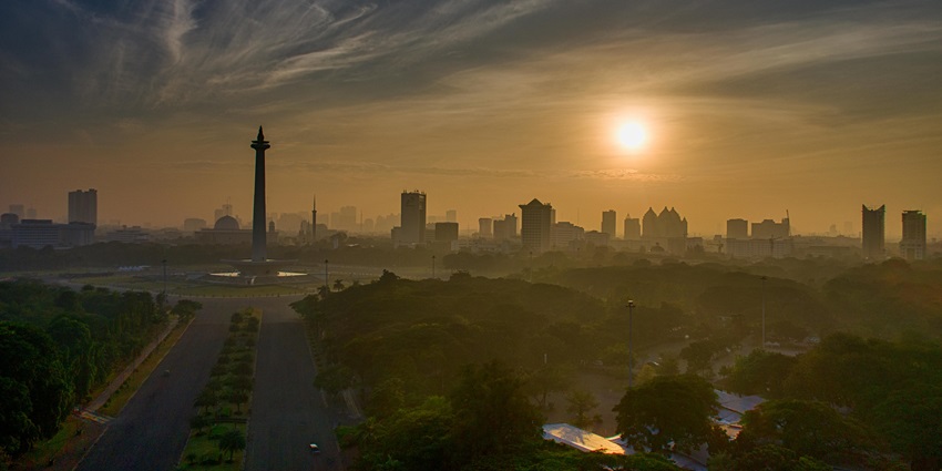An image of the city skyline during golden hour with warm sunlight illuminating the buildings.