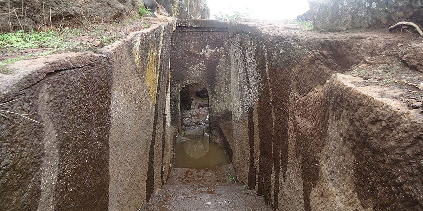 View of Ramshej Fort in Nashik, showcasing its stone walls and lush surroundings.