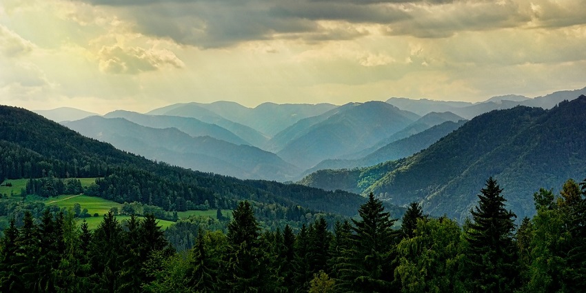 Majestic mountain peaks partially shrouded in clouds, creating a dramatic landscape scene
