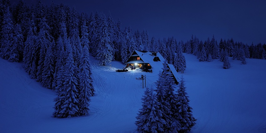 Snow-covered mountains under a clear blue sky showcasing a serene winter landscape.