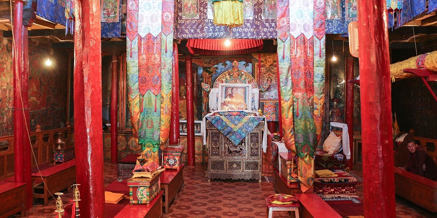 An interior view of a monastery with breathtaking architecture and idols during the day.