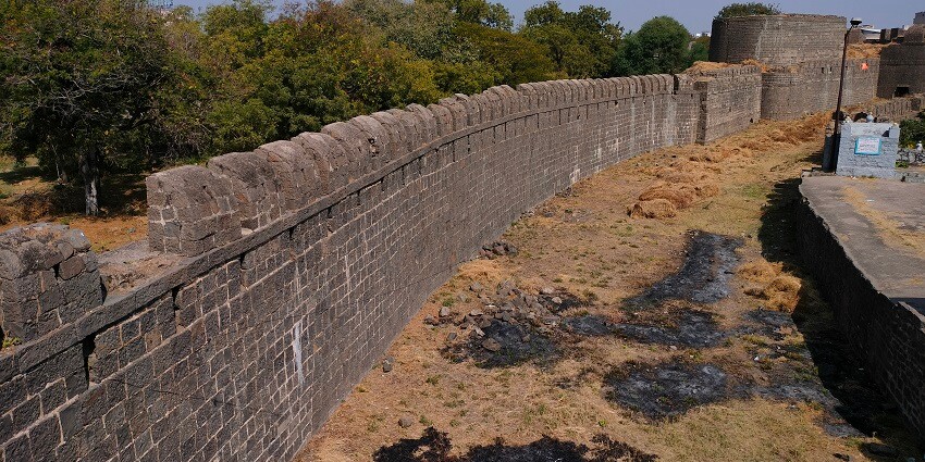 Outer wall and trench of Solapur Fort, showcasing its historical architecture.
