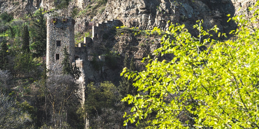 Image of a Fort ruins is surrounded by greenery and hills during day time