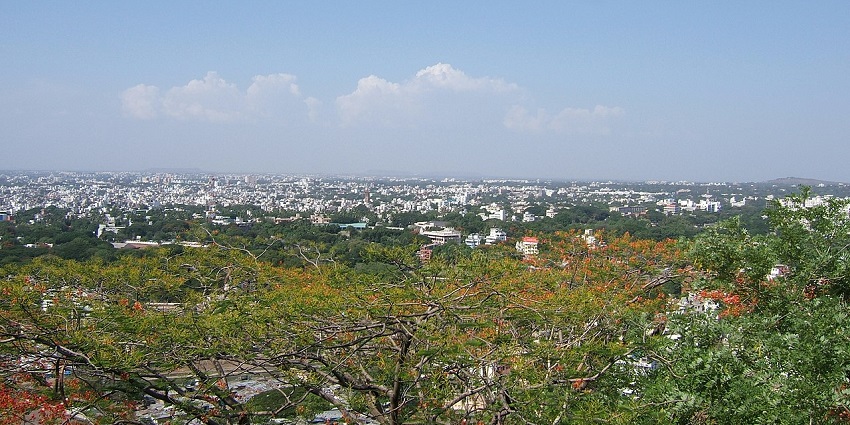 An aerial view of Maharashtra, showing a dense urban landscape with high-rise buildings.