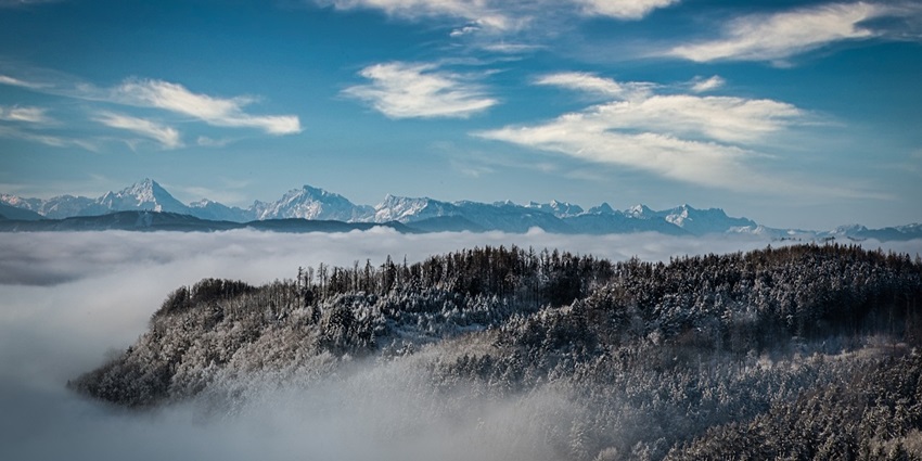 Majestic mountain peak surrounded by clouds, creating a stunning natural panorama.