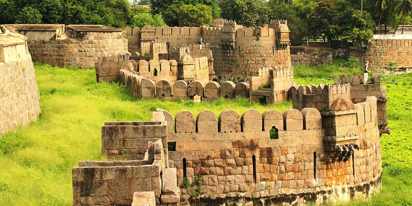 View of fort walls amidst lush green landscapes with dense forest in the background