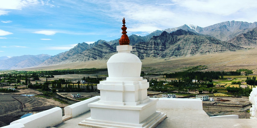 A mesmerising view of a white dome surrounded by lush greenery during the daytime.