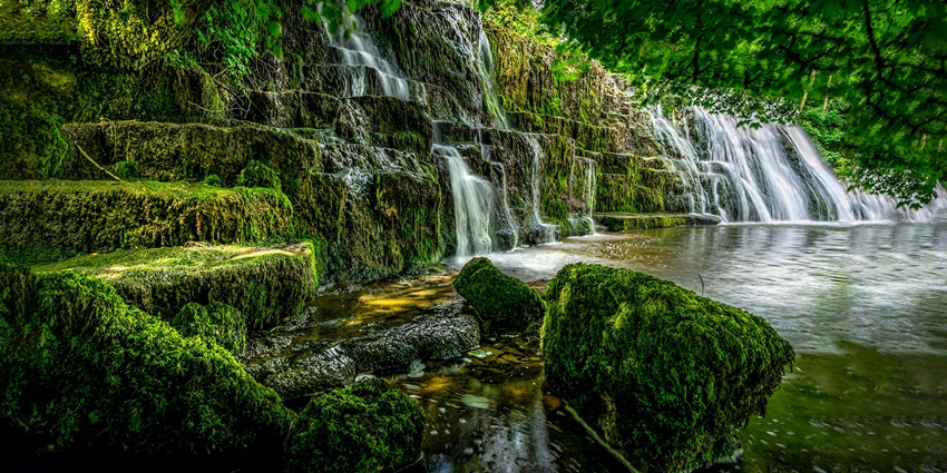 View of waterfalls from verdant and majestic mountains