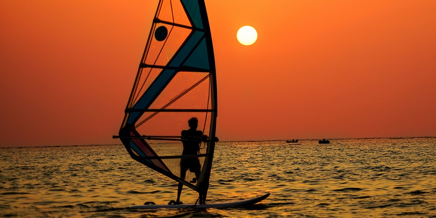 A picture of a tourist enjoying stand-up paddleboarding at a beach in Lakshadweep