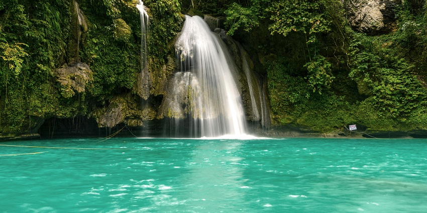 The tranquil Khandi Waterfalls reflecting the sky and surrounded by greenery in Maharashtra