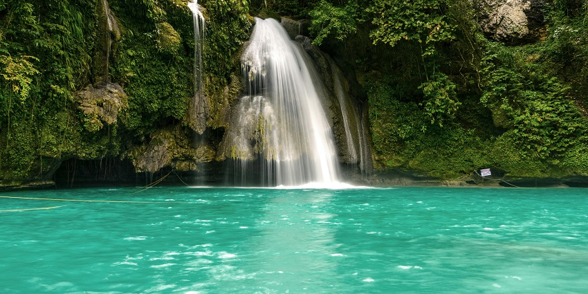 The Vajrai Waterfalls cascading over rocks, surrounded by vibrant greenery and natural beauty.