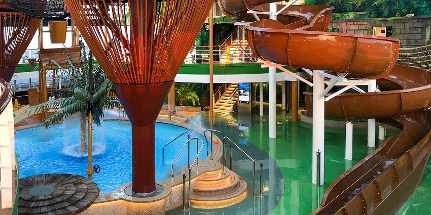 A picture of a water park with a lazy river and multiple water slides