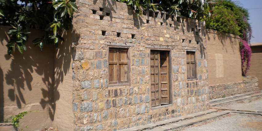 A picture of an old home made with bricks and wood shed, located near the Bhagat Singh Museum
