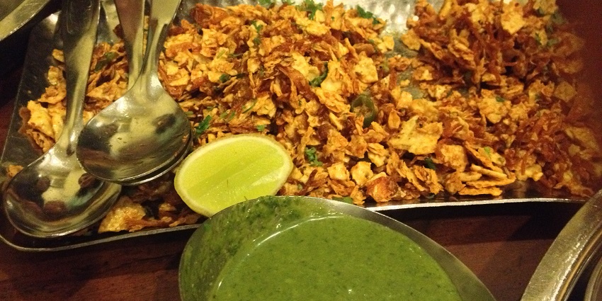 Spiced papad churi served with lemon wedge spicy green coriander and mint chutney.