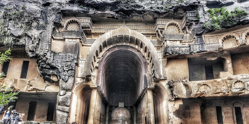 Ancient structure of the Bhaja caves with carved pillars and stone steps from the front