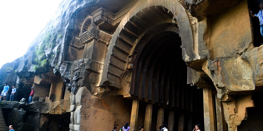 Tourists at the entrance of the ancient rock-cut architecture of Bhaja caves in Maharashtra