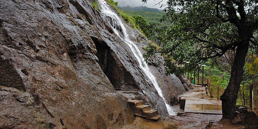 A cascading waterfall surrounded by lush greenery, creating a picturesque monsoon retreat, one of the best places to visit in Kamshet.