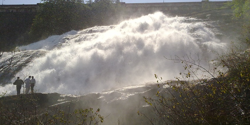 Stunning view of Bhandardara's waterfall surrounded by lush green mountains.