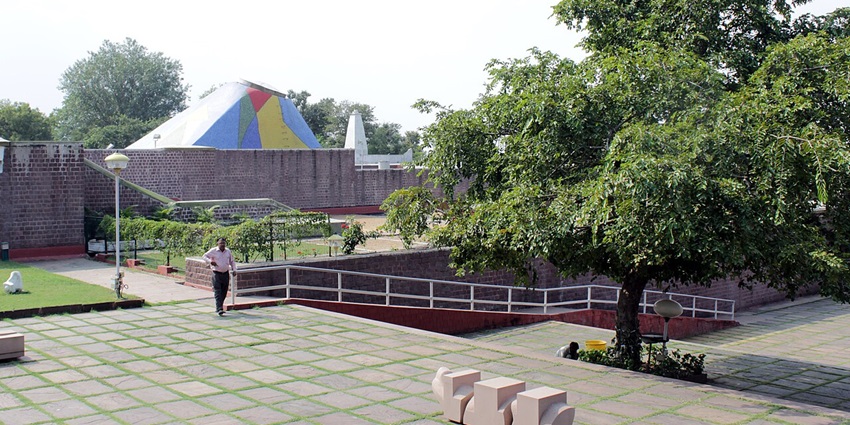 A picture of the inner compound of an art museum in Bhopal, with numerous trees all around