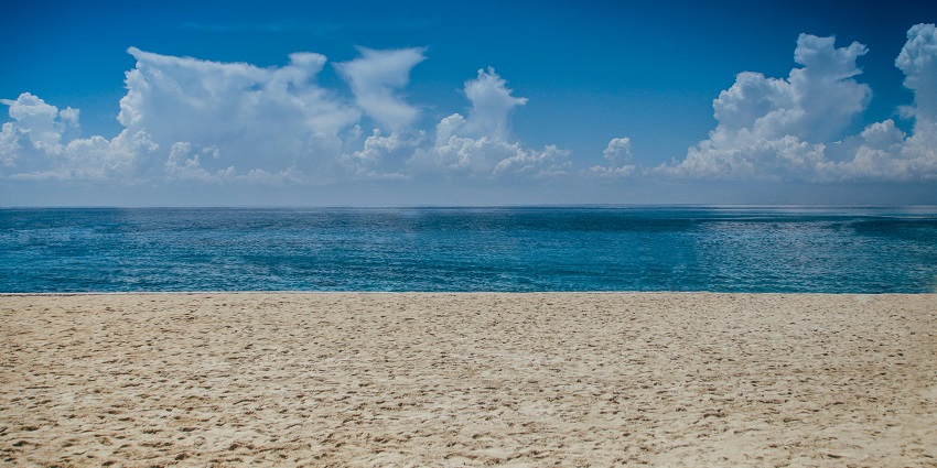 Vibrant ocean view under bright daylight, showcasing shimmering waves and clear skies.