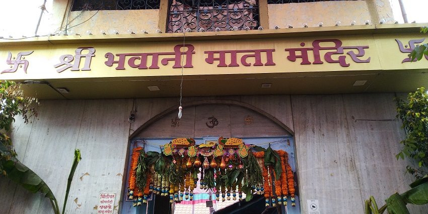 An image of Bhavani Mata Temple set against lush hills and intricate architecture.