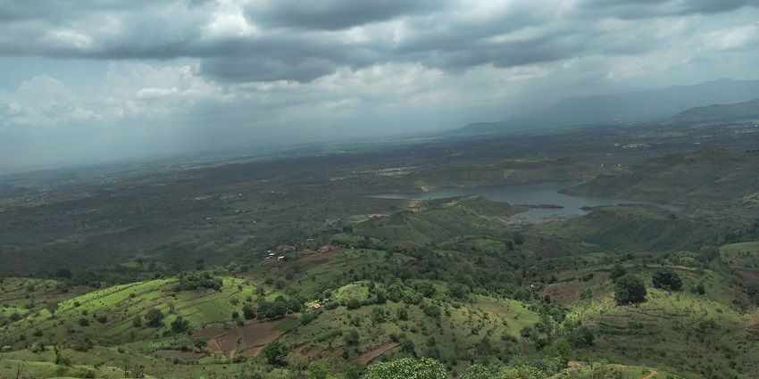 A panoramic view of Bhivpuri showcasing dense greenery and distant hills.