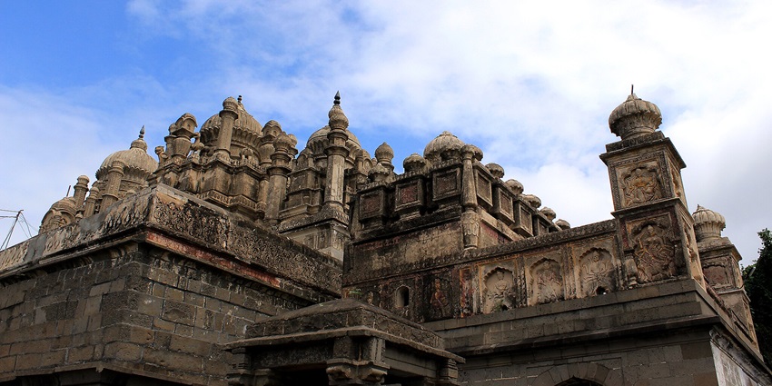 A picture of Bhuleshwar Temple is nestled amongst nature, an old piece of architecture.