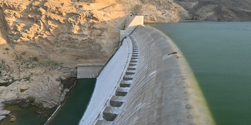 Waters of Bhushi Dam from the closeup surrounded by hills and a tower at a distance.
