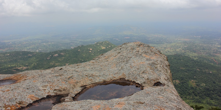 A picture of a scenic hill top near Kanakapura, with tranquil views of nature in the background