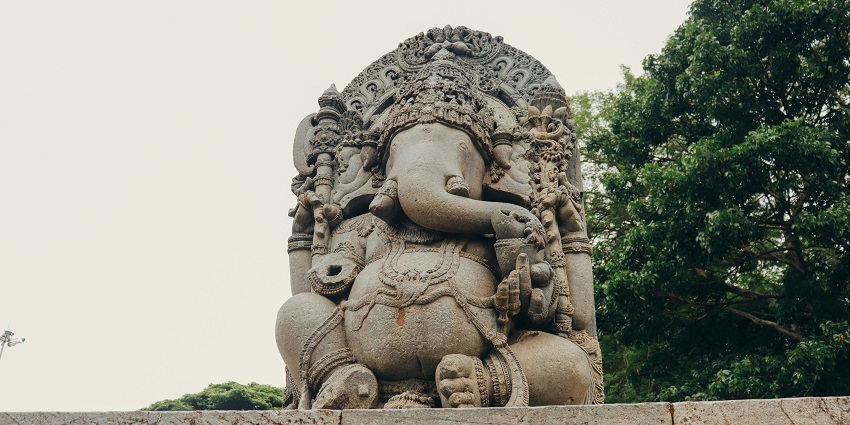 An idol of the Lord Ganesha, surrounded by greenery, a top attraction in Maharashtra.
