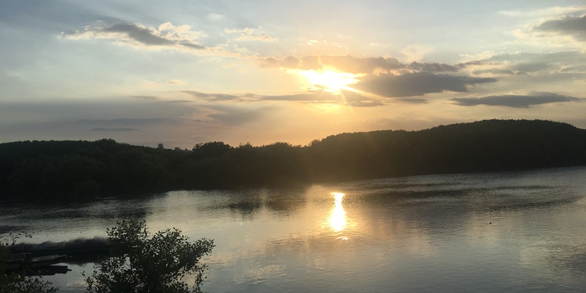 Sunset over the Arasalar River at Karaikal Beach, with the sun casting a golden reflection