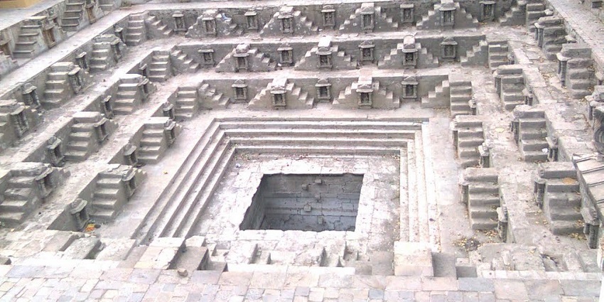 Ancient stepwell with intricate carvings, lush greenery, and serene ambiance.