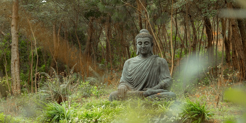 An image of Brahma Vihara Arama, a peaceful Buddhist monastery with intricate stone carvings