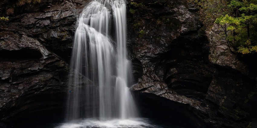 A serene waterfall flowing into a river from top of hills, a tourist attraction near Nangartas Waterfalls.