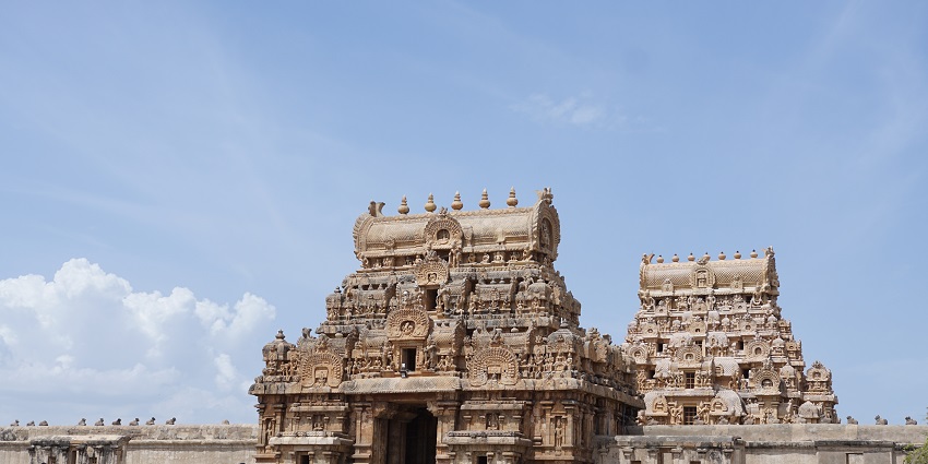 The majestic Brihadeeswarar Temple with its towering gopuram under a clear blue sky.